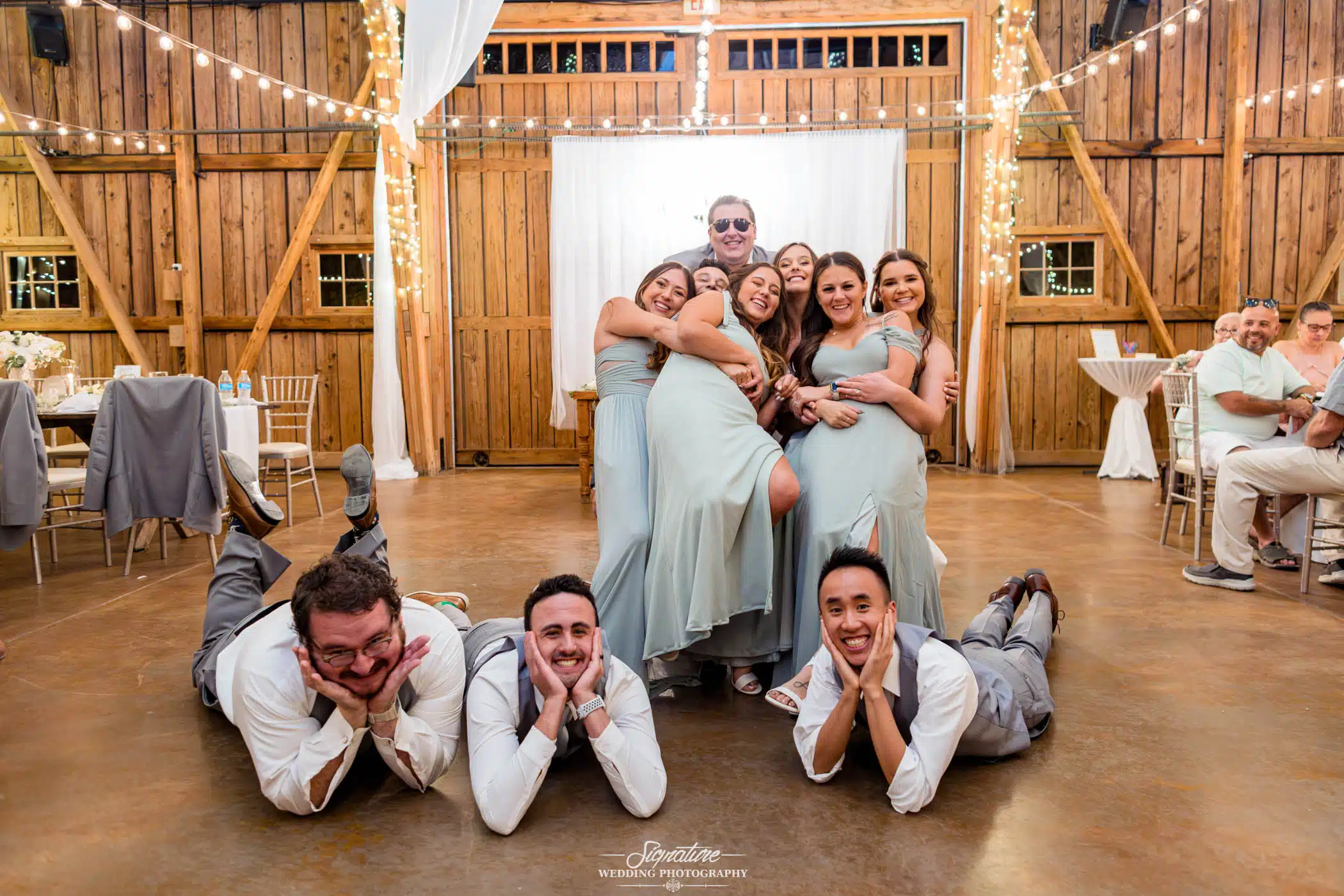 Image by Signature Wedding Photography candid group shot of bride and groom with wedding party