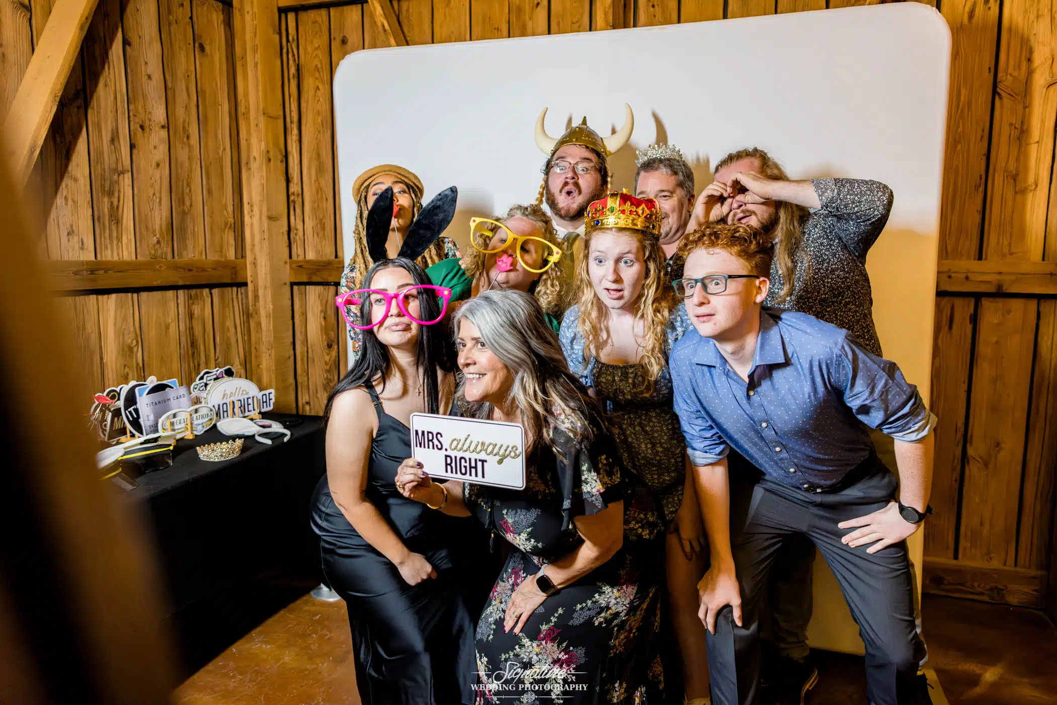 Image by Signature Wedding Photography candid photo of group at a wedding in a photo booth