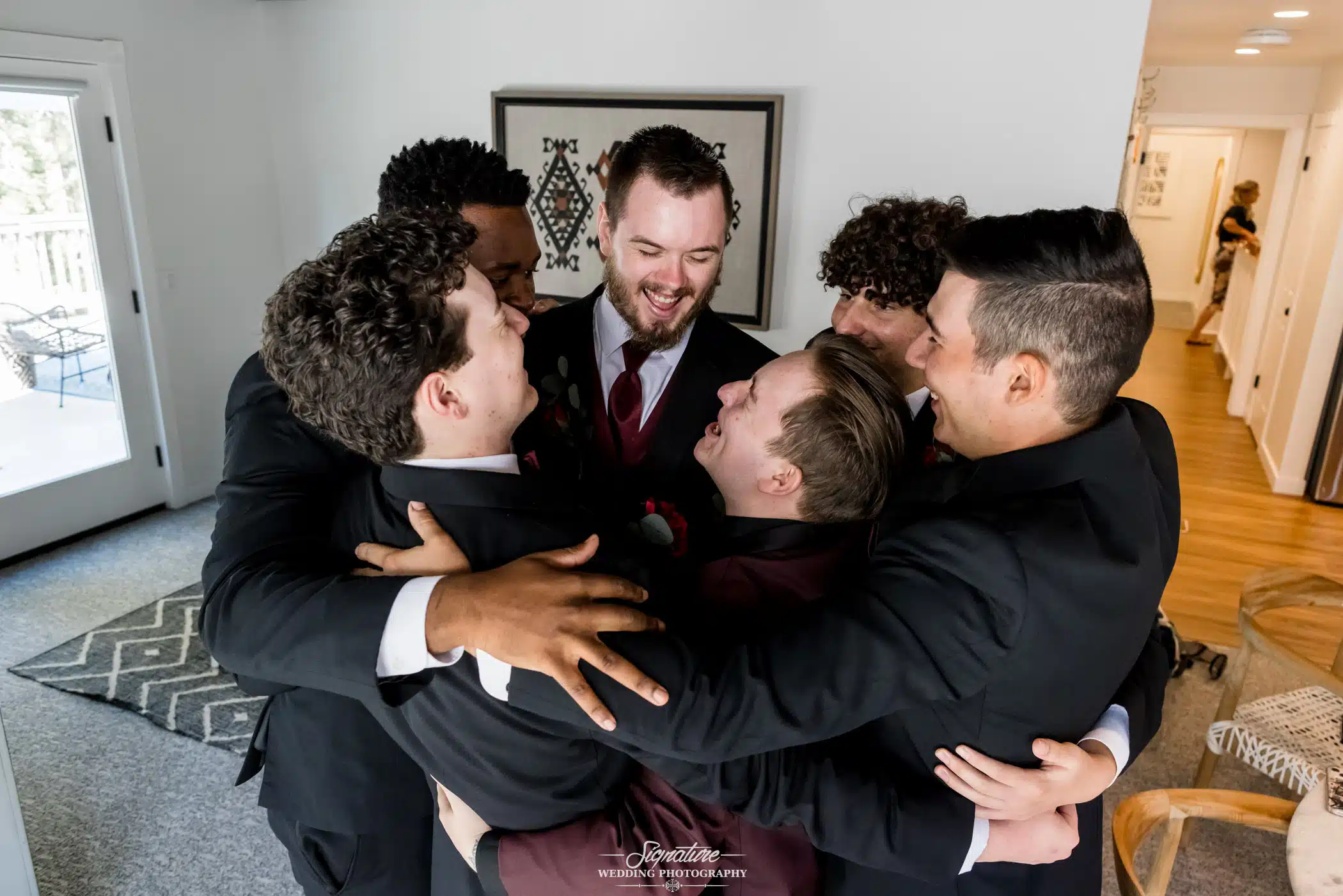 Image by Signature Wedding Photography candid group hug with the groomsmen