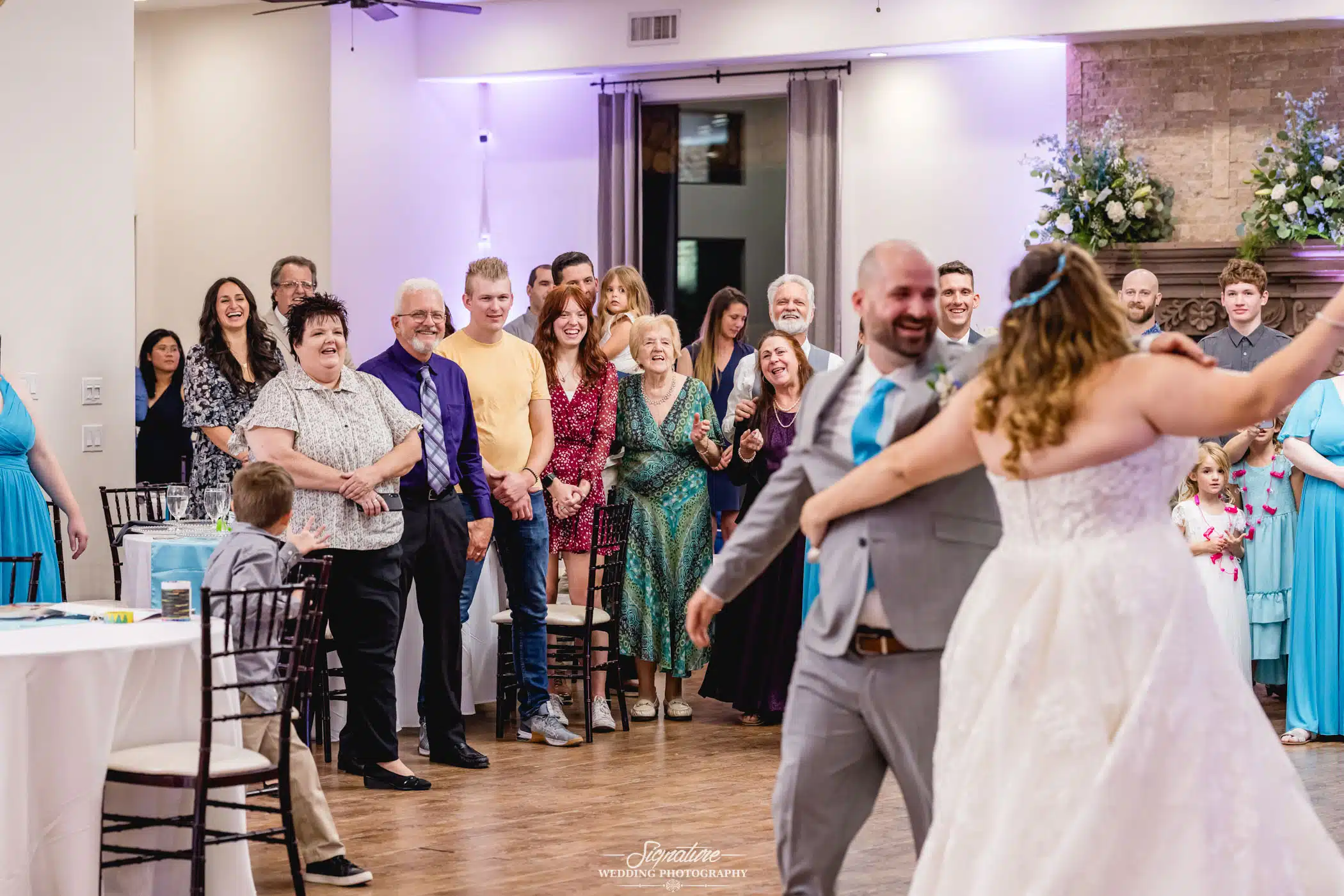 Image by Signature Wedding Photography newlywed couple dancing while their guests look on