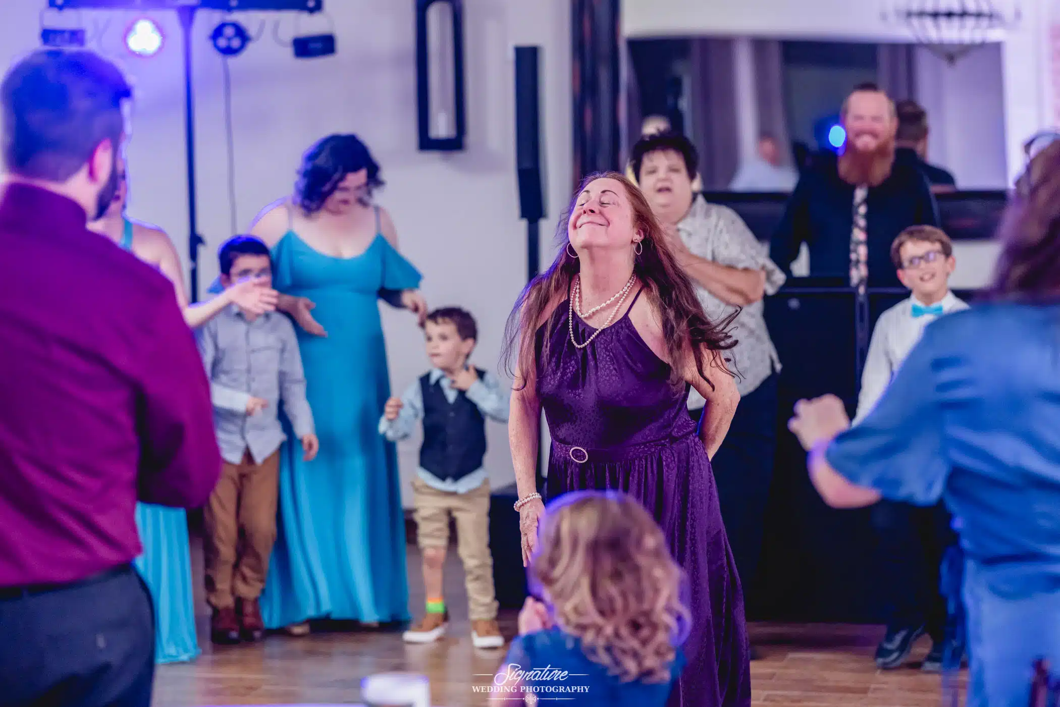 Image by Signature Wedding Photography candid shot of a woman dancing at a wedding reception