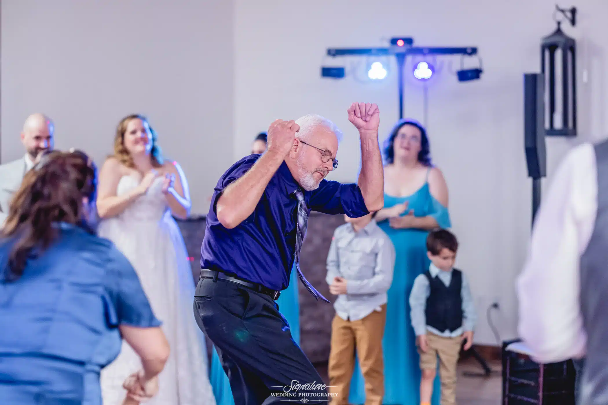 Image by Signature Wedding Photography candid shot of a man dancing at a wedding reception