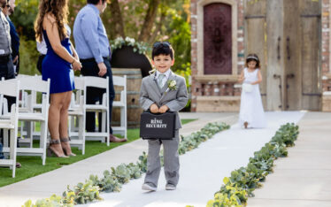 Cute ring bearer boy carrying ring in black briefcase