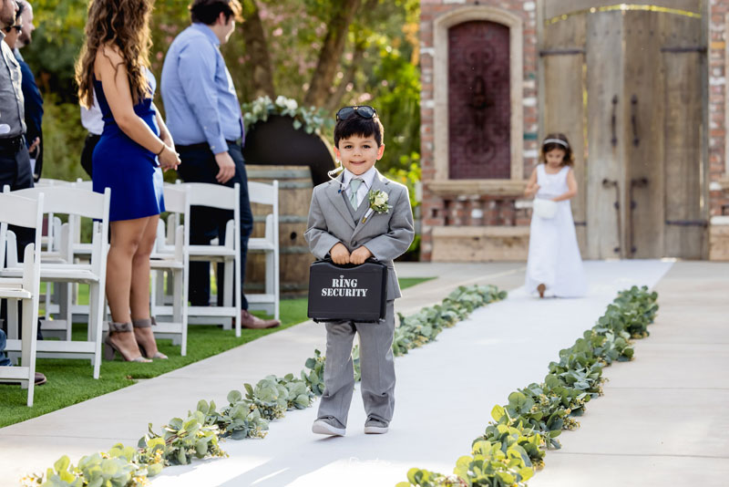 Cute ring bearer boy carrying ring in black briefcase